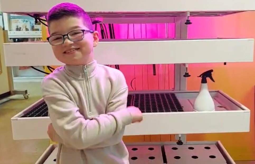 Anthony, kinderklimaatburgemeester Almere, bij de kunstlicht installatie GrowWizzKid, waarin hij eetbare plantjes heeft gekweekt.